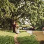 Bride and groom walking by canal boats