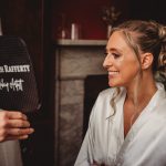 Bride viewing makeup in hand-held mirror