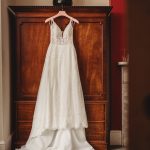 Elegant white wedding dress hanging on wardrobe