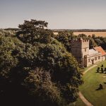 Aerial view of historic countryside church and cemetery.