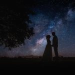 Silhouetted couple under starry night sky