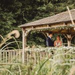 Couple exchanging vows in a garden gazebo.