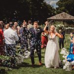 Bride and groom celebrating with guests and bubbles.