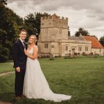 Bride and groom outside a historic church.