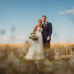 Bride and groom in wheat field wedding photo