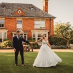 Bride and groom holding hands in garden