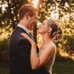 Couple embracing outdoors during sunset.