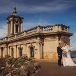 Bride and groom outside historic lakeside chapel