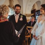 Bride and groom smiling during wedding ceremony.