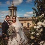 Bride and groom by waterside chapel