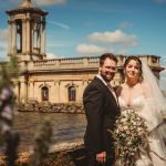 Bride and groom by lakeside church