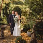 Bride and groom in a garden setting.