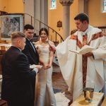 Priest officiating wedding ceremony inside a church.