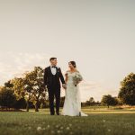 Bride and groom walking in scenic parkland