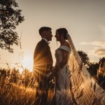 Silhouetted couple at sunset wedding scene