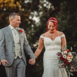 Bride and groom holding hands outdoors.