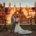 Bride and groom in front of historic mansion