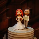 Bride and groom cake toppers on wedding cake.