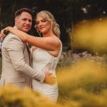 Wedding couple embracing in wildflower meadow