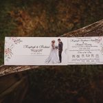 Floral wedding invitation on rustic wooden background.