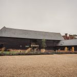 Rustic wooden barn with gravel courtyard.