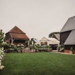 Countryside barn with manicured lawn and flowers.