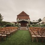 Outdoor wedding ceremony with floral decorations and chairs.