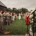 Bride walking down the aisle with father, outdoor wedding.