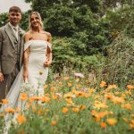 Bride and groom in a garden of wildflowers.