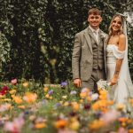 Wedding couple in garden with wildflowers.