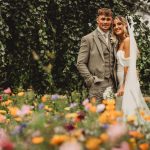 Bride and groom smiling in a floral garden