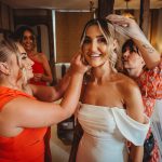 Bride getting ready with bridesmaids' assistance