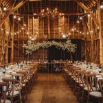 Rustic barn wedding reception with floral decorations.