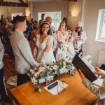 Bride and groom during wedding ceremony with guests.