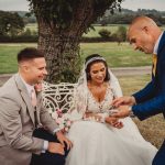 Bride and groom enjoying a magic trick outdoors.