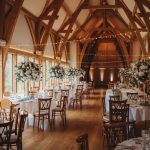 Elegant barn wedding reception with floral decorations.