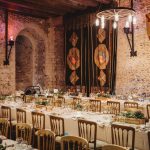 Medieval banquet hall with long decorated tables.