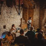 Wedding speech in medieval stone hall.