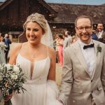 Bride and groom smiling at wedding celebration.