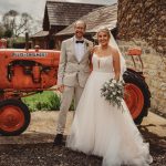 Bride and groom beside vintage tractor