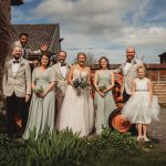 Wedding party posed by vintage tractor.