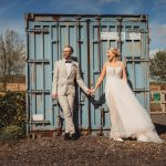 Bride and groom holding hands outdoors.