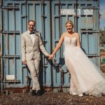 Wedding couple holding hands by blue container