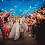 Bride and groom with sparklers during wedding celebration.