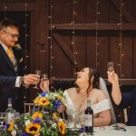 Bride and guests toasting at wedding reception.