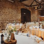 Rustic wedding reception with fairy lights and tables.