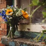 Colourful bouquet resting on rustic windowsill.