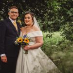 Bride and groom in garden with bouquet