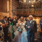 Bride and father walking down wedding aisle.