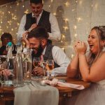 Bride and groom laughing during wedding speech